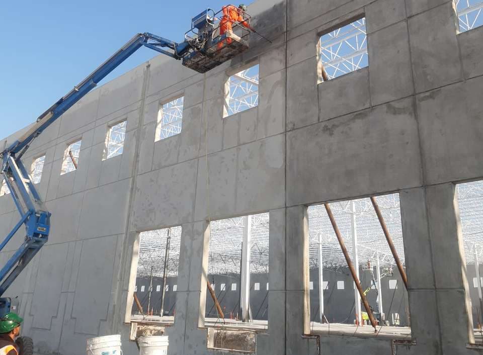 Fachada de nave industrial en proceso de acabado por Grupo BAXE
